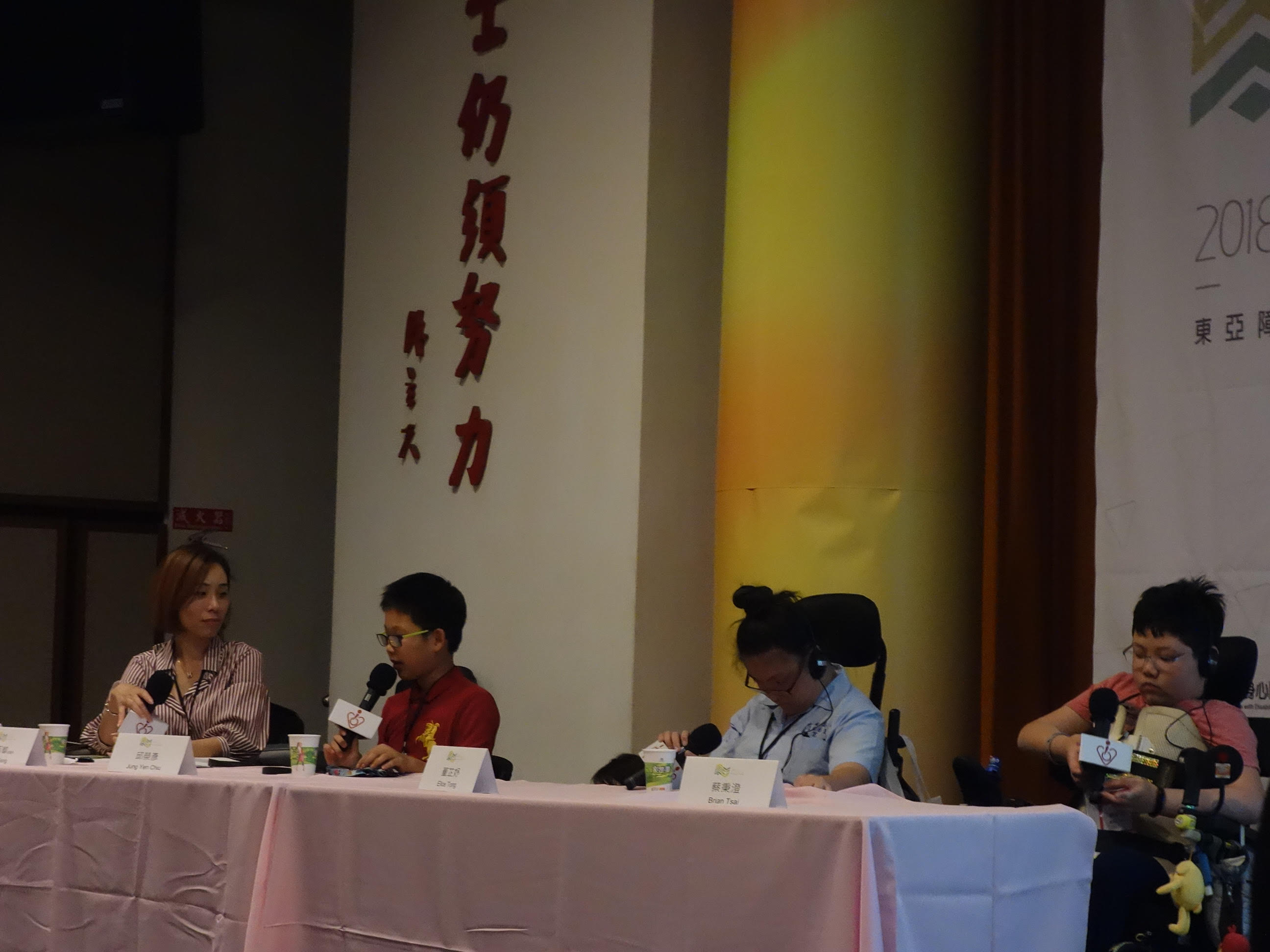 三位兒童與談人與主持人滕西華坐在長桌後輪流發言，兩位與談人為輪椅使用者